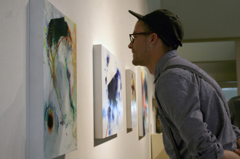 Tom Pekovitch, a graduate art major, studies Chris Kahler, an art professor's painting Dialumens 8A on Thursday at the Tarble Arts Center.