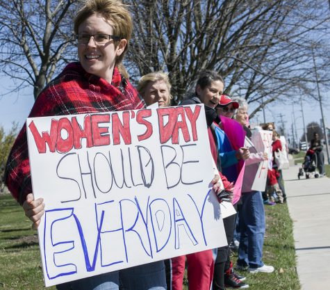 Jessica Mertz, a Charleston resident, holds a sign during the International Women’s Day protest Wednesday along Lincoln Avenue.