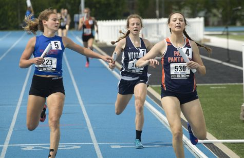 Kristin Slaughter (left), a senior from St. Anthony High School races with Bree Rochkes (right) from Pana High School and another competitor in the preliminary round on Thursday during the 4x400 meter relay.