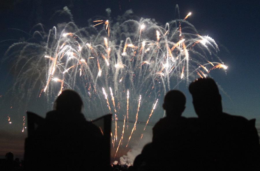 Jeff Riggs, his wife Kristen Riggs and their son Caleb Riggs watch the fireworks display at the Coles County Airport Friday as part of Red, White and Blue Days. The two-day celebration ended with the fireworks.