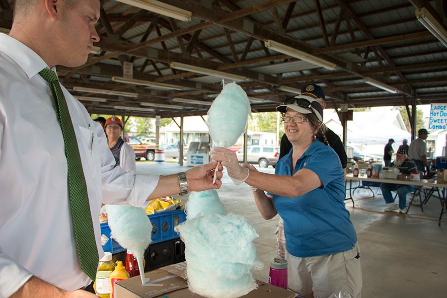 (Left) Colin Granville passes a cotton candy cone to (right) Melanie Mills, a retired Eastern professor, to sell for the Rotary Club Thursday at the Red, White and Blue Days celebration in Morton Park.