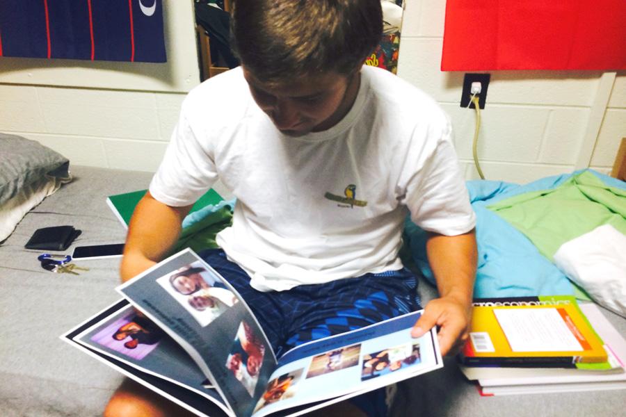 Dominic Recca, a freshman finance major, flips through a scrapbook detailing his time spent with his girlfriend.