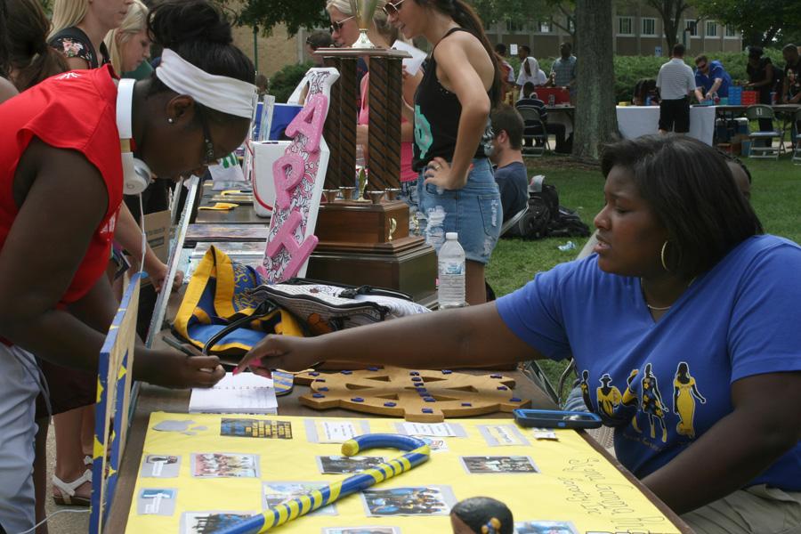 Chynna Miller| Daily Eastern News    
 
Regime Billingsly, a junior athletic training major, explains the sign up sheet for Sigma Gamma Rho Sorority, Inc. to Sarah Ampadu, a senior health studies major, at Panther Palooza Wednesday.
