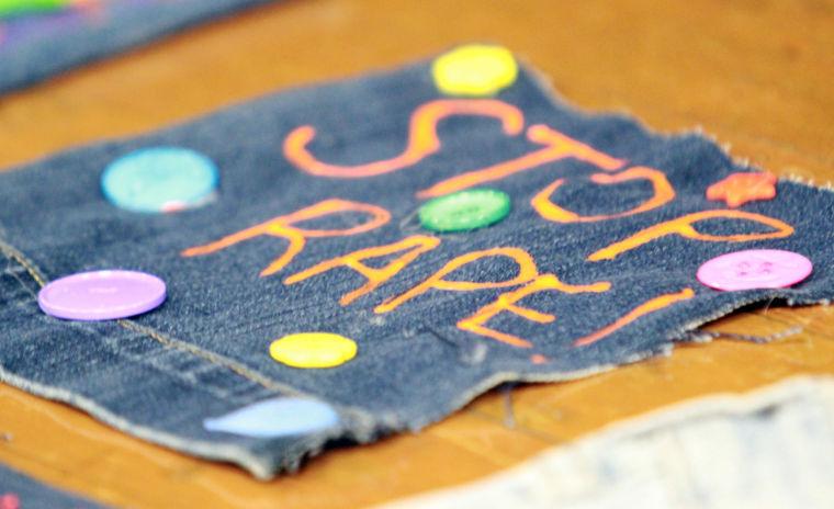Blue jeans are displayed on the stage of the Seventh Street Underground of the Martin Luther King Jr. University Union during Take Back the Night on April 10.  The denim was adorned with accessories and fabric paint in honor of a case in which a woman's battle against her attacker was challenged because she was 