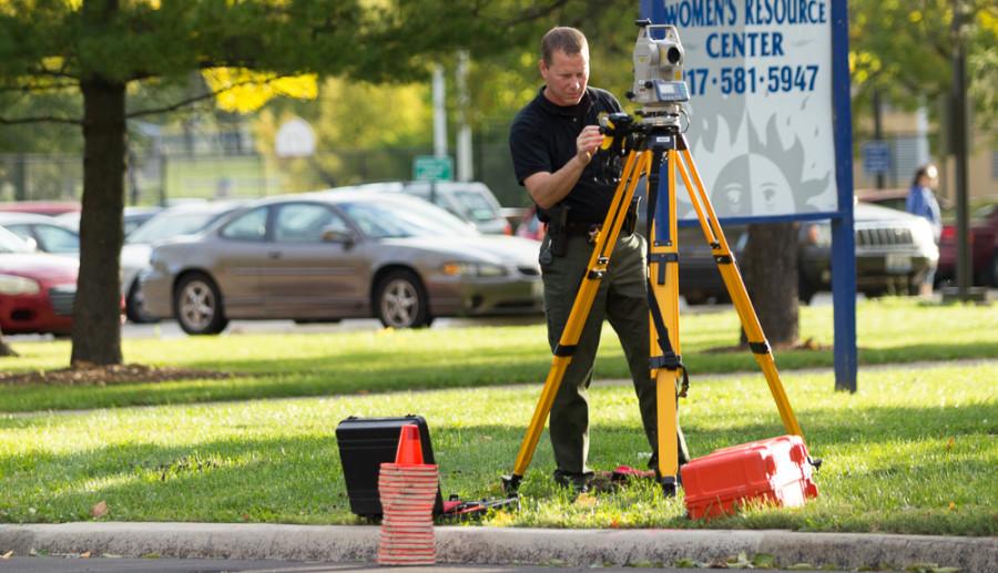An Illinois State Police trooper with the traffic crash and reconstruction unit analyzes the scene of a hit and run on Sunday at the pedestrian crosswalk between Lincoln Hall and McAfee Gym.  One subject was airlifted to Carle Foundation Hospital in Urbana.  According to Sgt. Justin Peterson of the Charleston Police Department, police are looking for a light green full size truck in connection with the hit and run.