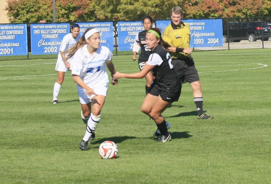 Senior Midfielder Meagan Radloff is grabbed by defender as she looks to make a play in the Friday afternoon soccer game.