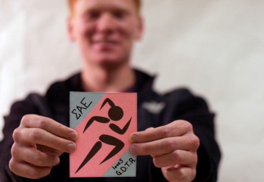 Colby Gerth, a sophomore biological sciences majorad member of Sigma Alpha Epsilon fraternity holds out a door decoration he made with other members of SAE. THe Fraternity is sponsoring the the Arcola Elementary Girls on the Run team, and made the decorations to hand out to each runner to show their support.