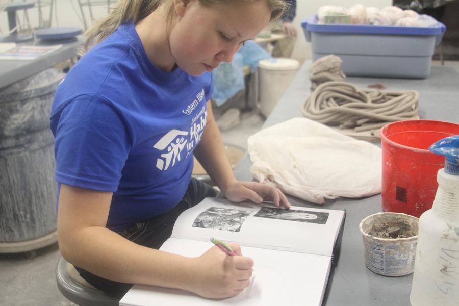Samantha Kriener, junior 3D arts major, sketches an owl and flowers that will later be a clay coin collector.