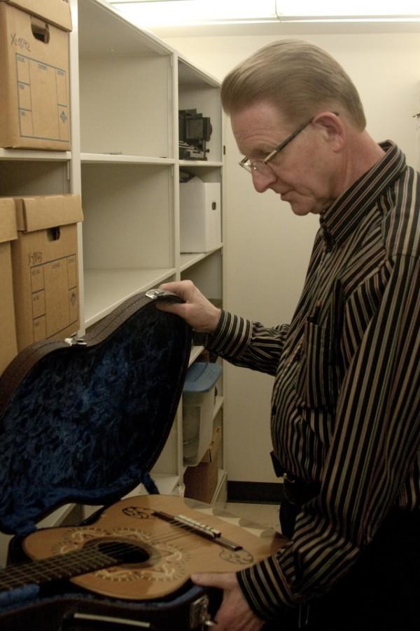 Robert Hillman, reference librarian and the university archivist for the past 25 years,  shows off some of the artifacts stored deep in the lower levels of Booth Library. Hillman retired Sunday.  Hillman looks at a guitar once in possession of musician Burl Ives, who dropped out of Eastern in 1929.