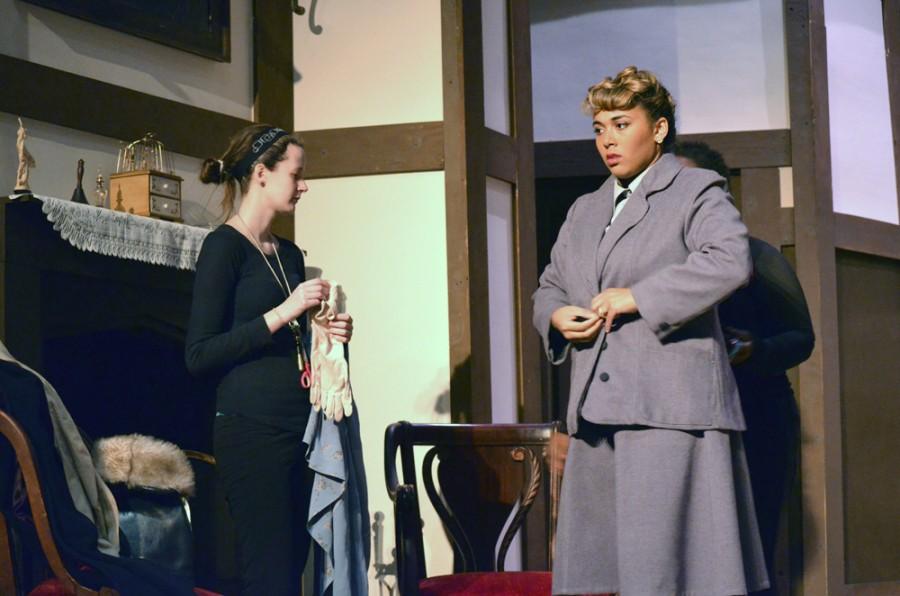 Kaycie Brauer, a senior english and costume crew runner, helps Leah Davis, a junior communications major, get into costume Wednesday during the tech rehearsal for The Mousetrap in the Doudna Fine Arts Center.
