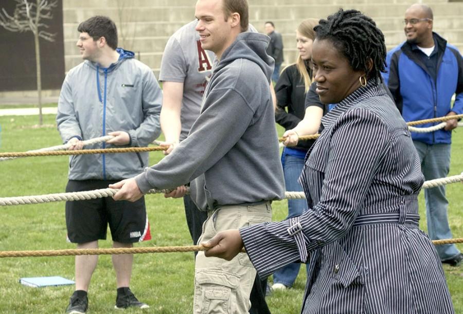 Catherine Polydore, an associate professor in counseling and student developement program, assists in pulling the rope at the Wall of Hate tear down Friday in the North Quad. Polydore was the first of two speakers to speak at the event.