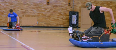 Junior pre-engineering major Tom Sticha and sophomore pre-engineering major Paul Blackmore race their race their hovercrafts on Saturday in the McAfee Gym.