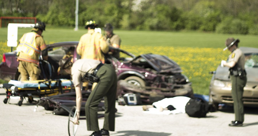 Members of the Illinois State Police and the Charleston Fire Department survey the scene of a staged drunk driving accident at Charleston High School. CHS staged a mock drunk driving accident before their prom to show high schoolers the dangers of drinking and driving.