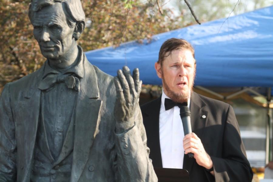Chuck Trent, a pastor at the Otterbein United Methodist Church, portrayed Abraham Lincoln Wednesday at the Coles County Fairground. Trent stands next to the Lincoln statue while reading sections of Lincolns speeches and some famous quotes from his life.