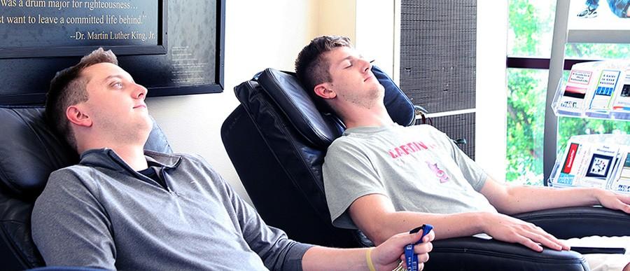 Senior finance major Clayton Cooper and Michael Van Popering try out the massage chairs in the Bridge Lounge of the Martin Luther King Jr. University Union. Cooper and Van Popering are from Charleston.