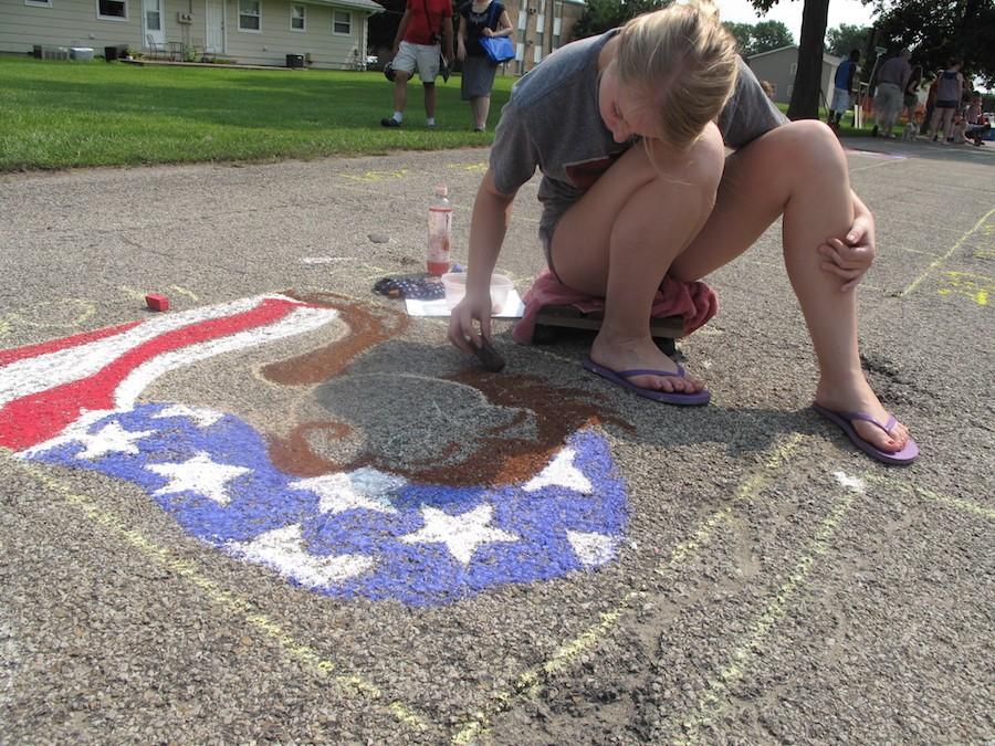 Hannah, a Chalk-In competitor in the high school division, draws a patriotic character for Red, White and Blue Days on Saturday in Morton Park.