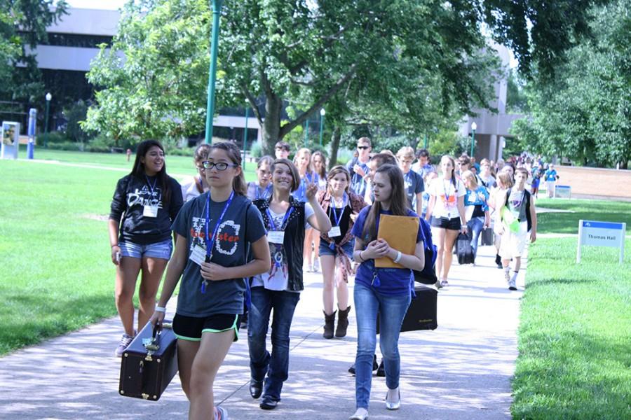 High school students participating in Eastern’s summer music camp walk with instruments in hand on the South Quad toward Andrews Hall on July 14, 2015 to have lunch between their music sessions that are held in Doudna Fine Arts Center.