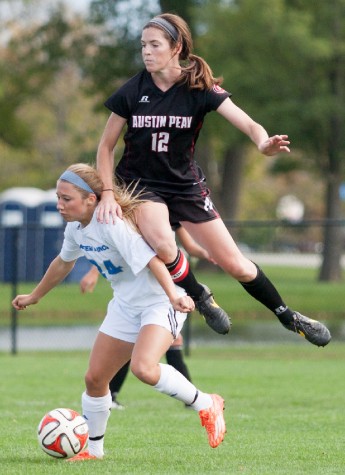 Sophomore forward Madi Fischer gains possession of the ball while senior Claire Pultz leaps on her during a match on Oct. 5 2014 at Lakeside Field. 