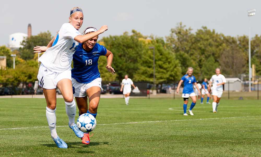 Freshman Kate Olson runs alongside IPFW's Paityn Fleming during the Panthers' 3-1 victory on Sept. 4 at Lakeside Field.
