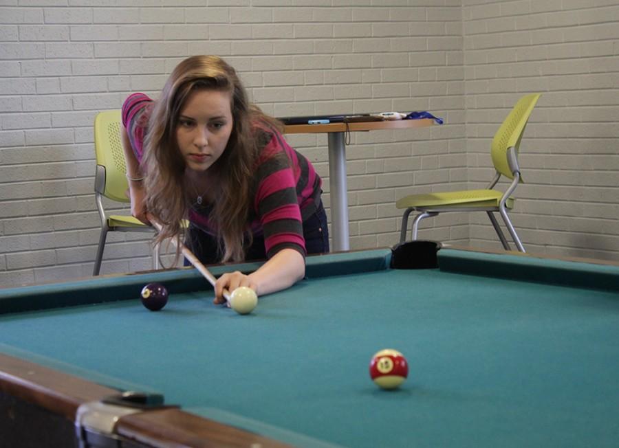 Kelsey Higgins, a freshman accounting major shoots pool on Monday in the lobby of Thomas Hall. Higgins said she shoots pool everyday with her friends.
