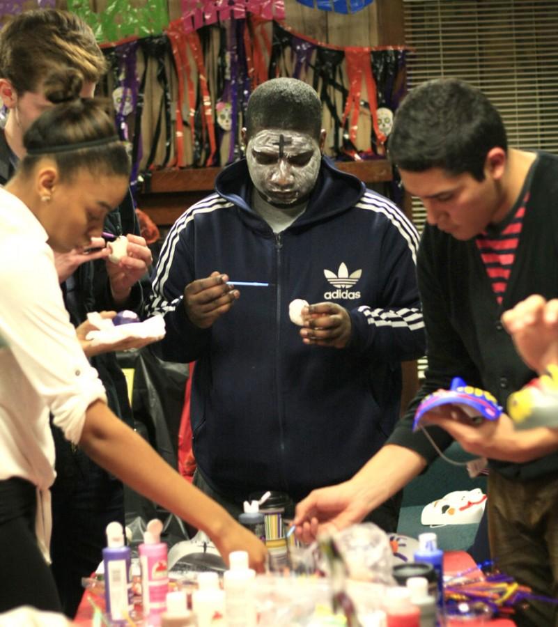 Darell Brewster, a sophmore communactions studies, paints a mask for the Day of the Dead party at the Cultural Center on Oct. 30, 2014.