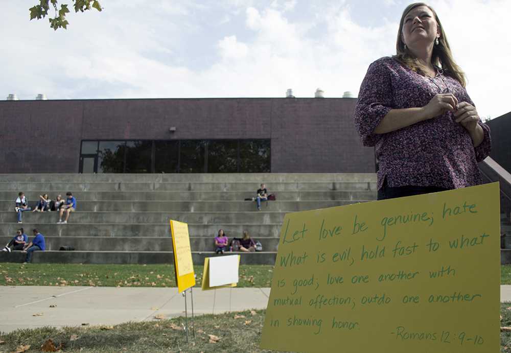 Paige Roberts, the campus minister at the Wesley Foundation, watches on as Reverend Mikhail Savenko and Mikhail Savenko speaks with students on Monday in the Library Quad. Roberts said the Grace Space allowed them to silently counter protest against radical evangelists.