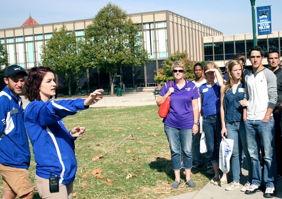 Jordan Landeck, a senior commuications major, informs a tour group of facts pertaining to the Doudna Fine Ats Center in the South Quad on Monday. She and Will Giroux (left), a sophomore health studies major, led campus tours during the open house.
