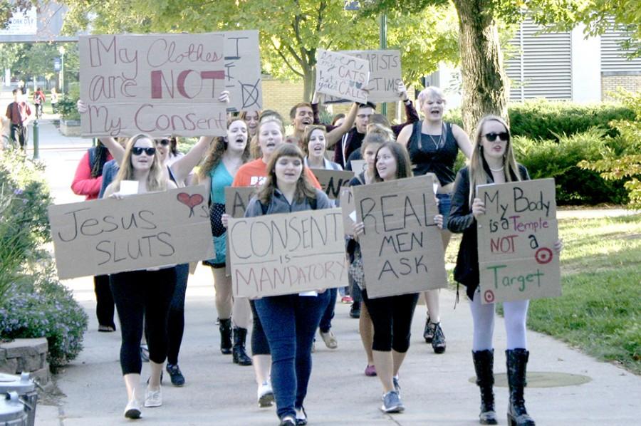 Students chanted and raised hand-written signs during the SLUT Walk while marching past the Biological Sciences building on Sept. 23, 2014.