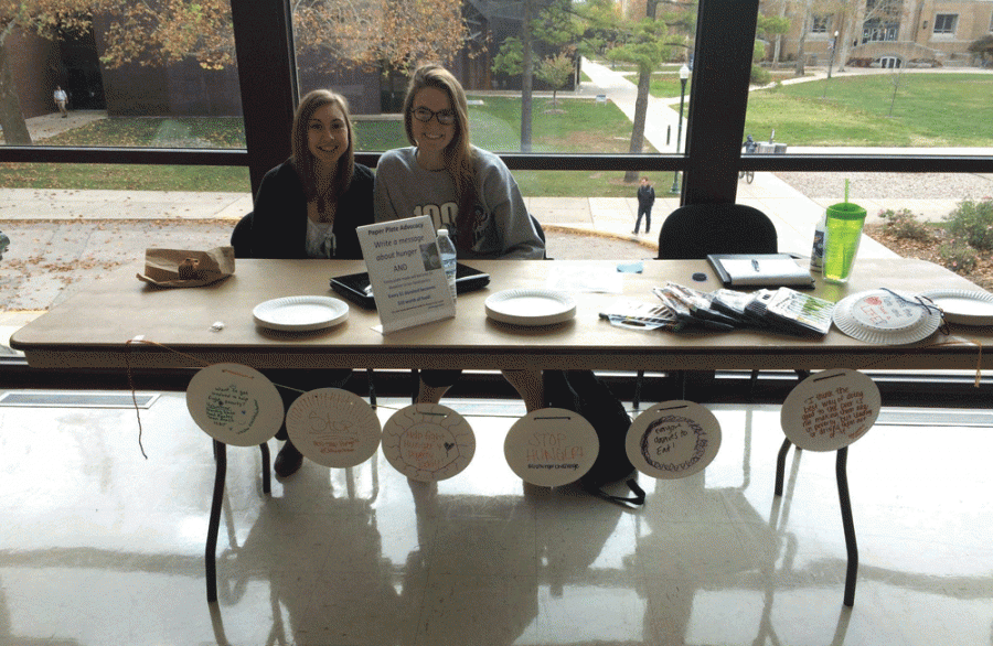 Larissa Kmetz, a junior sociology major, and Gretchen Butterfield, a sophomore biological sciences major, work with the Hunger action team and hand out plates for students to  decorate to send to the Wesley Foundation Food Pantry every Thursday of November in Bridge Lounge of the Martin Luther King Jr. University Union. With each plate decorated a dollar is donated to the food pantry.