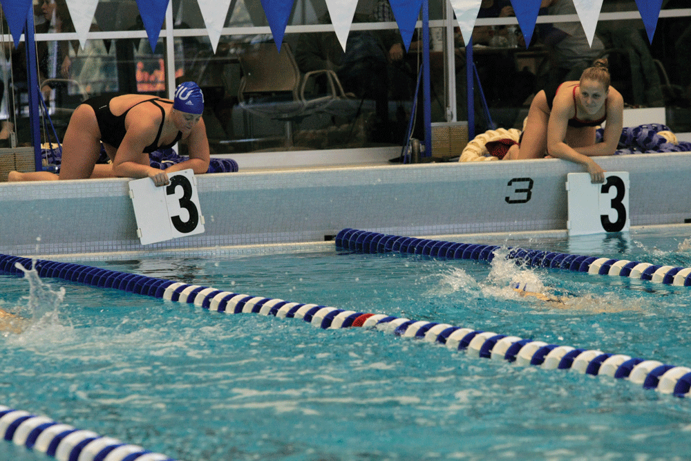 Sophomore butterfly and backstroke swimmer Niki Beringer signals what lap her teammate is on while swimming the Women's 1000 yard freestyle event in the meet against Indiana University-Purdue University Indianapolis on Oct. 17 at the Ray Padovan Pool.