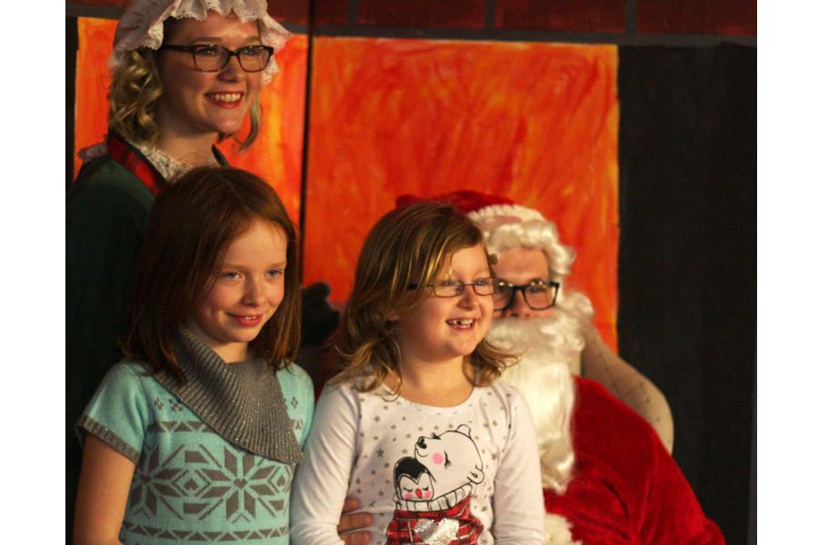 Greta Dieter junior political science major, dressed as Mrs. Claus, and John Jaso junior history, dressed as Santa Claus, sit with children at the NRHH Winter Wonderland event Monday night in the 7th Street Underground of the Martin Luther King Jr. University Union.