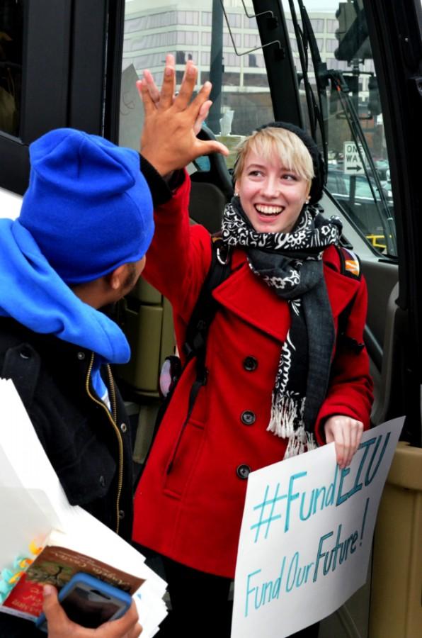 Sophomore communication studies major Annie Pettit gives Akeem Forbes, junior English major, a high-five before getting off the bus at the Capitol. Eastern students rally at the Capitol protest lack of budget.