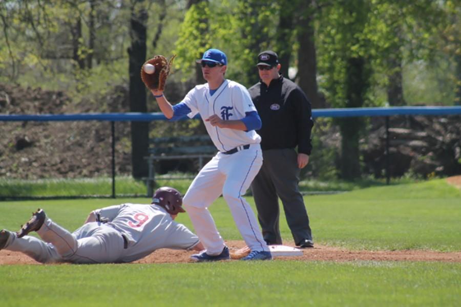 Former first baseman Adam Casson catches the ball in an attempt to get a player out at first base.