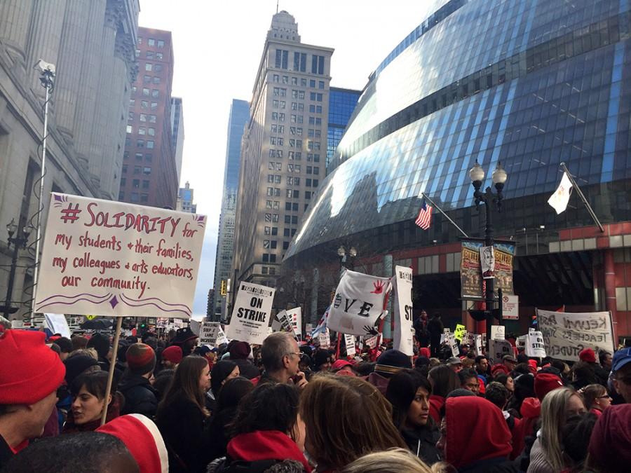 A mixture of professors and students from state universities stand outside the Thompson Center in downtown Chicago during a rally Friday. Some of the schools with representatives at the rally include Chicago State, Eastern Illinois, Northeastern Illinois, along with the Chicago Teachers Union.
