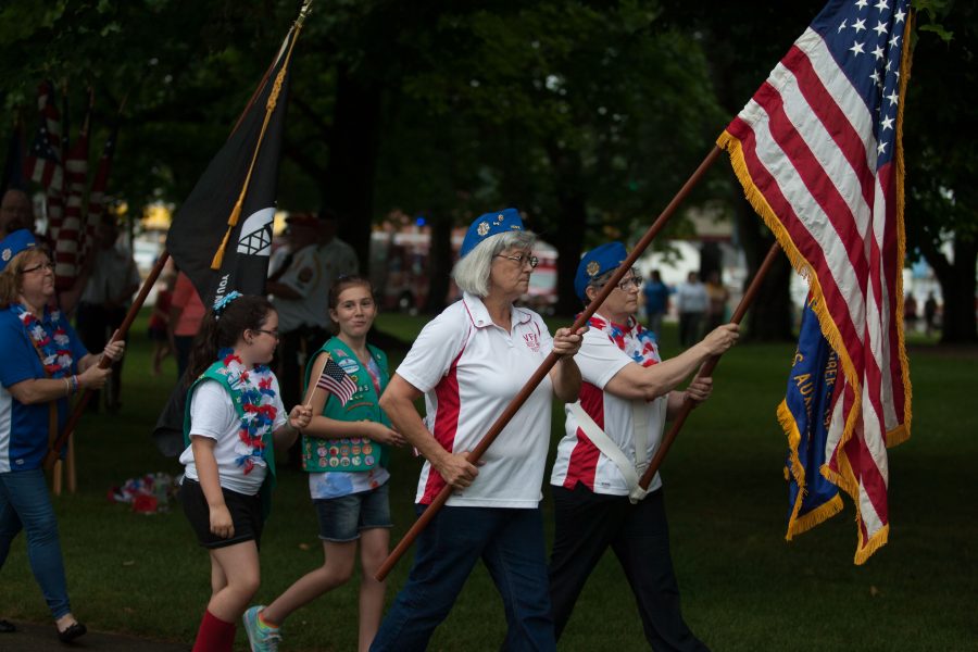 Members of the Girl Scouts and the VFW Ladies Auxiliary bring the flags in at the start of the bell ringing ceremony on Monday at Morton Park.