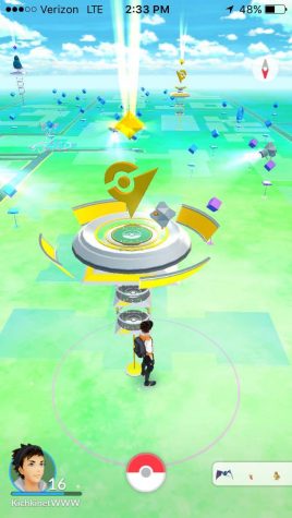 A screenshot from the game showing gyms on campus standing in front of Old Main. Other gyms include the Tarble Arts Center, Booth Library and O'Brien Field. Players vie for control of gyms by battling their Pokemon against the Pokemon left to defend the gym by the other colored team. 