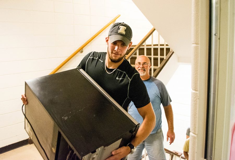 Nick Edges, a psychology major, helps carry a micro-fridge up the stairs at Lawson on Thursday.