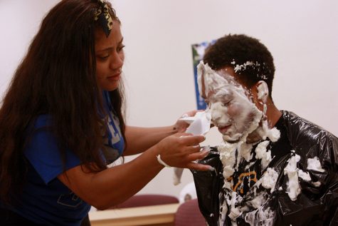Senior kinesiology and sports studies major Kathryn McIntosh helps senior marketing major Chris Johnson “CJ”, the social chair for Alpha Phi Alpha, clean off his face at a mixer on Thursday Sept. 10, 2015. Mixers are one of the many events fraternities and sororities hold on campus. 12 of the 26 different organizations are registered for the fair.