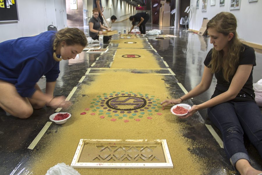 Jason Hardimon | The Daily Eastern News Kristi Zoubka, a sophomore athletic training major, and Rachel Washburn, a sophomore elementary education major work together on an alfombra for Eastern’s Spanish club. “The freehanding is going a lot better than I thought it would,” Zoubka said. “We’re kind of rainbow hombreing it.”
