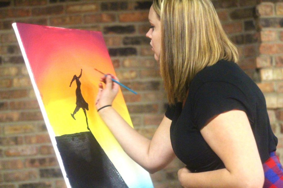 Morgan Tudor, a senior psychology major works on painting a picture during A Night of Empowerment in the 7th Street Underground. It represents taking a leap of faith when we feel hopeless Tudor says.