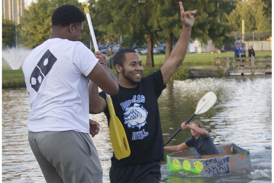 Shawn Hammers (right), a freshman political science major, celebrates winning the boat relay with his friend Tauhaun Mason (left), a freshman undecided major, Thursday at the campus pond. “Number one in the race, number one in your hearts,” Hammers said. 