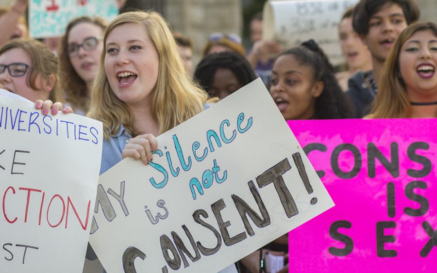 Students and community members chant, “claim our bodies, claim our right, take a stand, take back the night,” during the S.L.U.T Walk Tuesday in front of Old Main.