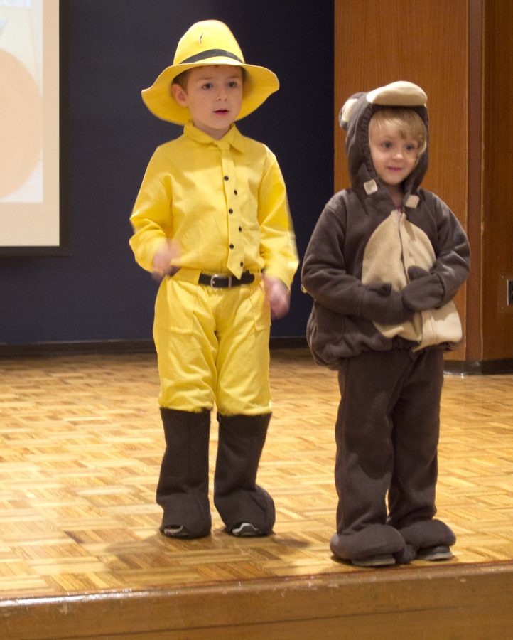 Dressed in the Man in the Yellow Hat and Curious George customes model charleston community children participate in the costume contest during the Annual Kids Fun fest in the grand ballroom of the Martin Luther King Jr. University Union ballroom. During the fest all children model on their Halloween costumes on the stage and the winner earns a bag of candy.