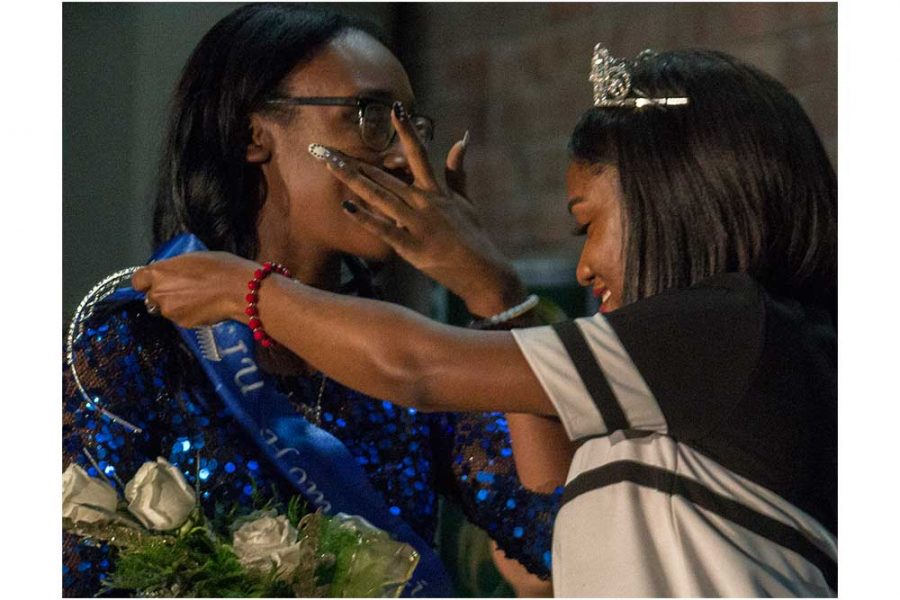Khayla Kelley-Morton, a junior family and consumer sciences major, wipes tears from her eyes as she is crowned homecoming princess by last year’s princess Astoria Griggs-Burns, a senior health adminstration major, during the Homecoming Corination Cerimony Monday in McAfee Gym.