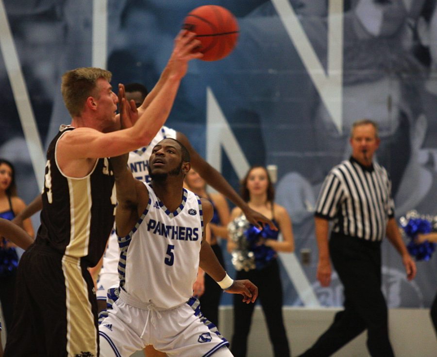 Junior Ray Crossland attempts to shield the passing lanes with his hand while defending a St. Francis (Ill) player Friday at Lantz Arena.
