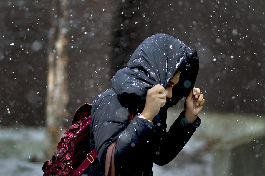 An Eastern student does her best to avoid the snow as she made her way to Doudna Fine Arts Center Wednesday.