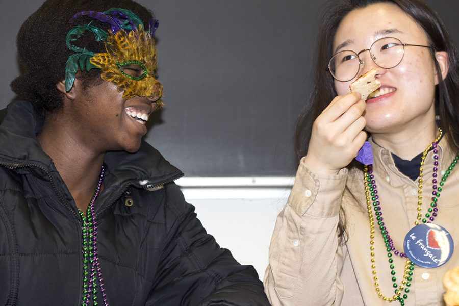 Anita Saffa, a junior economics major, and Jane Kim, a junior exchange student from South Korea snack as part of their participation in The Mardi Gras celebration in Coleman hall.