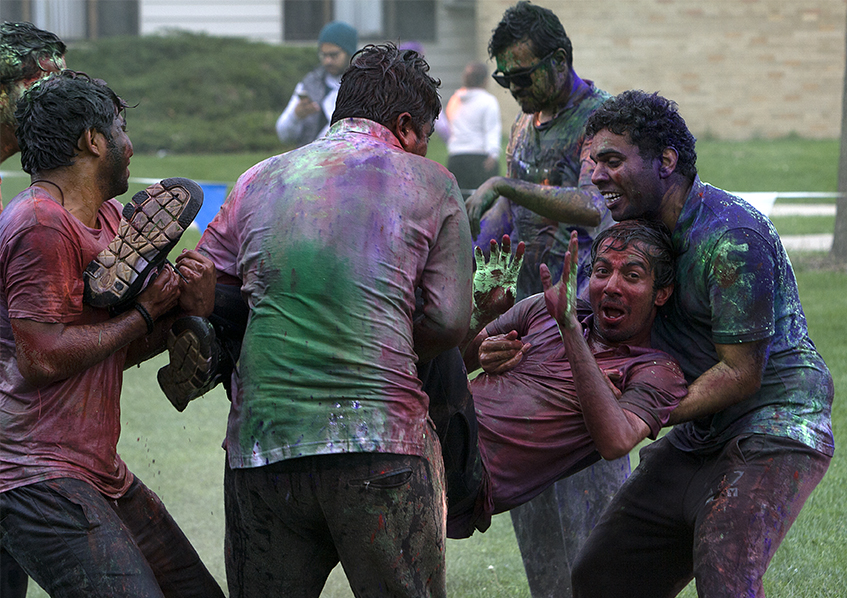 Kishore Bandarupalli, graduate student in the school of technology is carried by a group of friends Saturday at the HOLI event in the Library Quad.