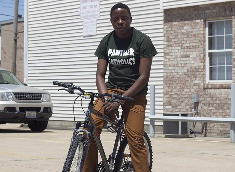 Simon Walingo, a graduate student from Uganda, poses on his bike Monday afternoon. Walingo said he plans on spending his summer in Charleston balancing a job and an online class.