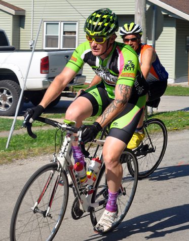 Two cyclists race past houses in Lerna Saturday during the 50-mile race at the Tour de Charleston.